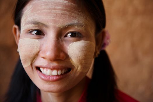 Portrait of beautiful young traditional Myanmar girl smiling. Close up head shot.