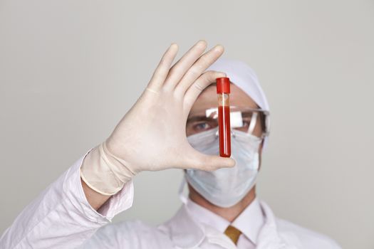 Doctor holding a beaker of blood