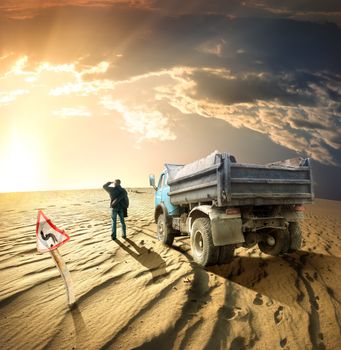 Man and a truck in the desert at sunset