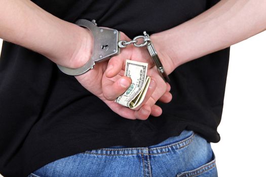 Handcuffs on the Hands with a Money Closeup Isolated on the White Background