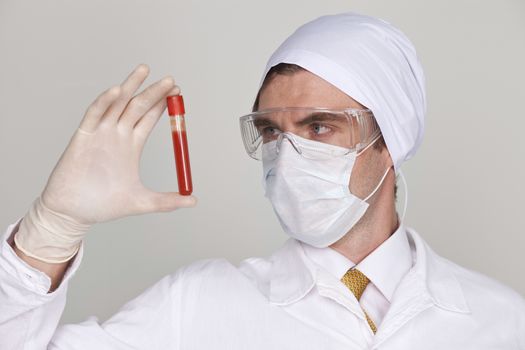 Doctor holding a beaker of blood