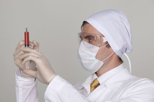 Confident surgeon holding a syringe against a white background