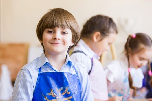 Little children painting and playing at kindergarten