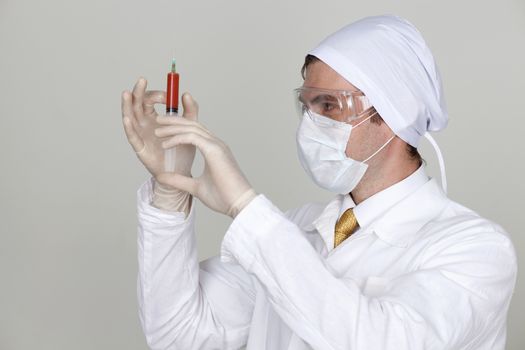 Confident surgeon holding a syringe against a white background