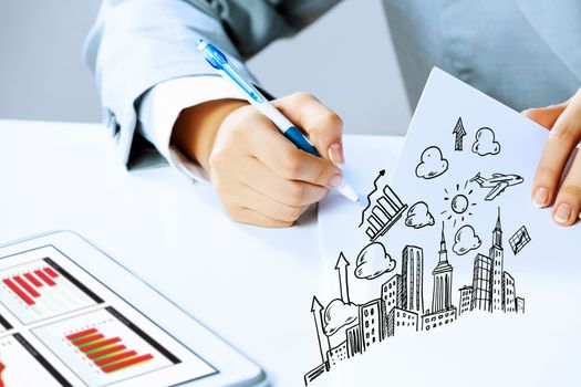 Image of businesswoman sitting at table and drawing sketch