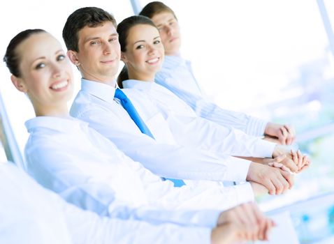 young business people holding hands, standing in a row, the concept of teamwork