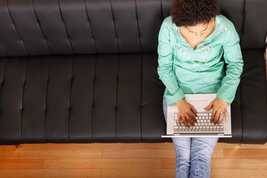 A young, brazilian woman surfing on the Internet with a Laptop.  