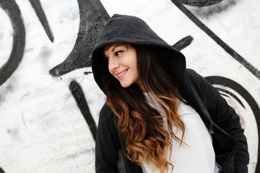 A young woman leaning on a wall.