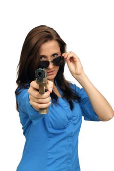 A lovely young brunette points a modern handgun at the camera.  Selective focus on the handgun.  Isolated on a white background with generous copyspace.