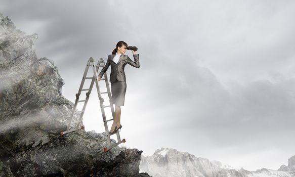 Image of businesswoman standing on ladder and looking in binoculars