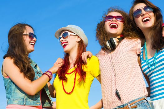 Image of four young attractive girls having fun outdoors