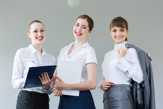 Image of attractive businesswomen holding folders and discussing