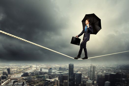 Image of pretty businessman balancing on rope