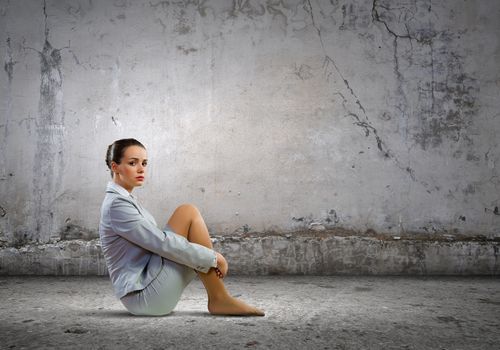 Image of young upset businesswoman sitting alone