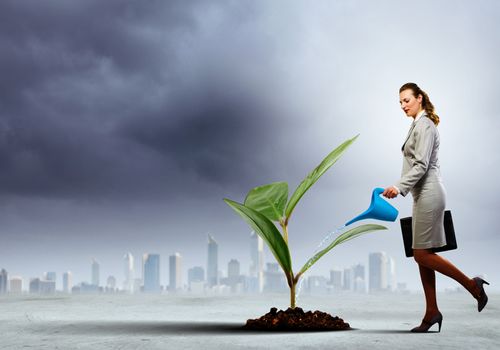 Image of businesswoman watering tree with pot. Ecology concept