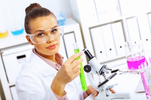 Young female scientist working with liquids in laboratory