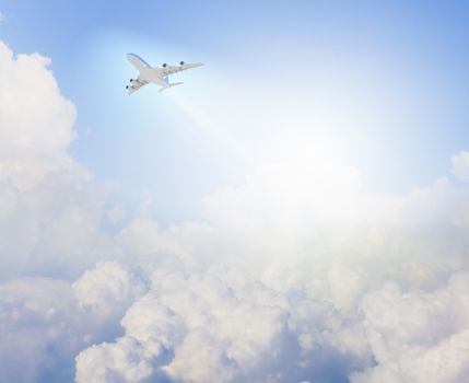 Image of flying airplane in clear sky with sun at background