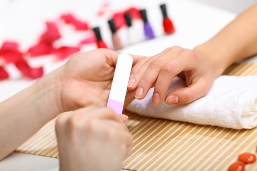 Young woman is getting manicure in a beauty salon