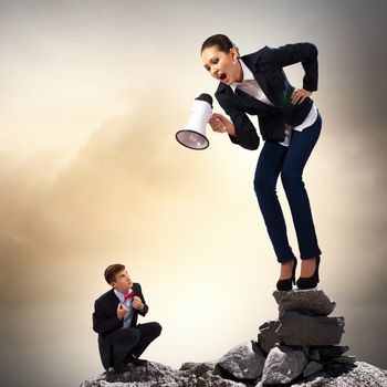 Angry businesswoman with megaphone shouting at colleague