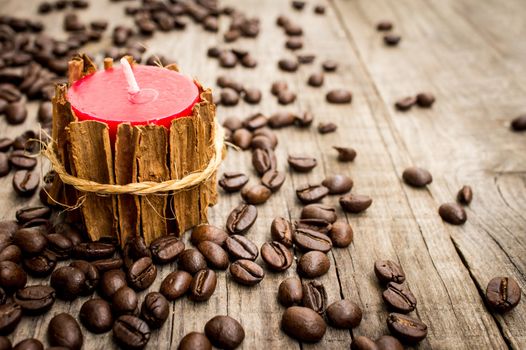 Candle wrapped in cinnamon on wooden textured background