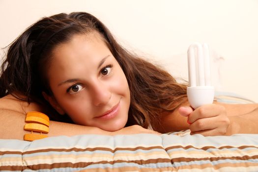 Young girl with a energy saver light bulb.