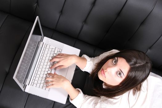 A young woman surfing on the Internet with a Laptop.  
