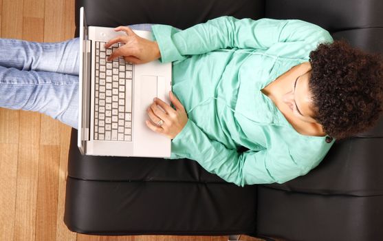 A young, brazilian woman surfing on the Internet with a Laptop.  