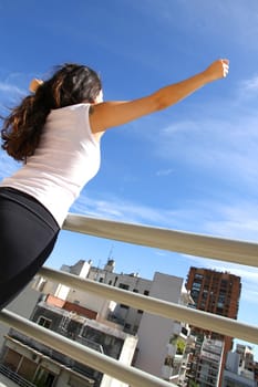 A young adult woman practicing Yoga in an urban environment.