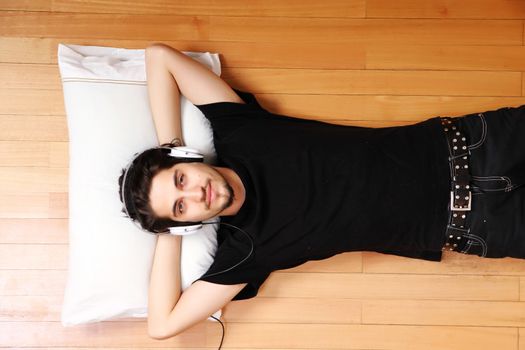 A young hispanic man listening Music with headphones.