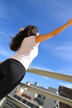 A young adult woman practicing Yoga in an urban environment.