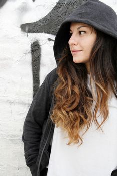 A young woman leaning on a wall.