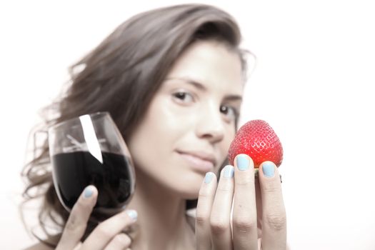 Portrait of a beautiful, latin Woman eating a Strawberry and drinking wine.