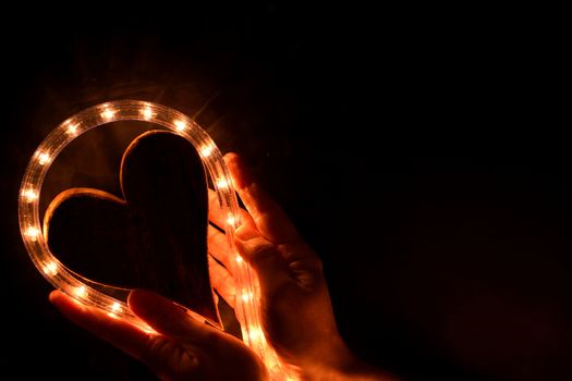 Hands holding an illuminated heart