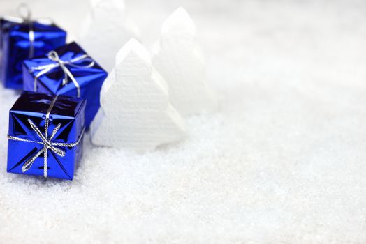 Blue Christmas presents in the snow with white trees