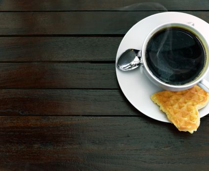 Cup of steaming coffee and a fresh waffle