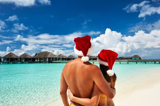 Couple in santa's hat on a tropical beach at Maldives