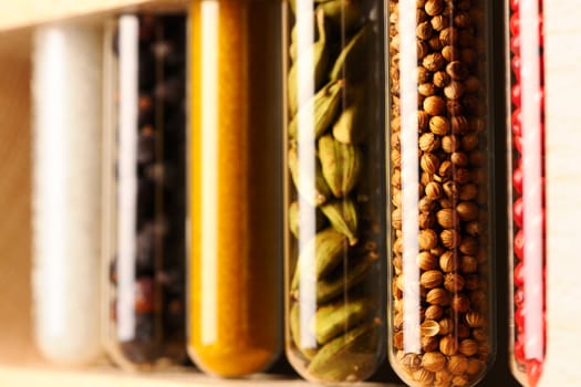 Spices in beakers against dark background