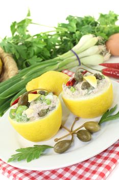 stuffed Lemons with tuna cream, capers and eggs on a light background