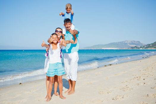 Family of four having fun on tropical beach