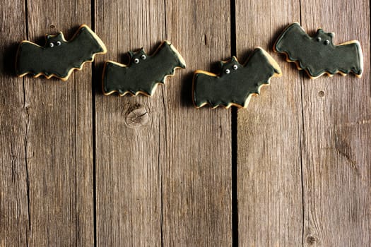 Halloween homemade gingerbread cookies over wooden table