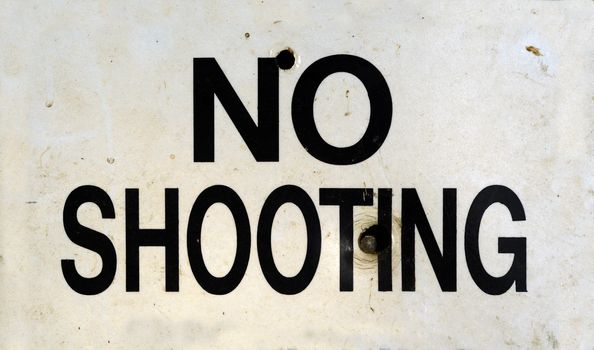 Grungy No Shooting Sign With Bullet Holes