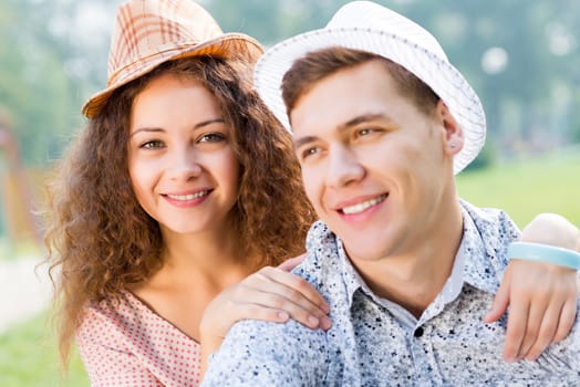 romantic couple lying on the grass in the summer park, spending time with loved ones