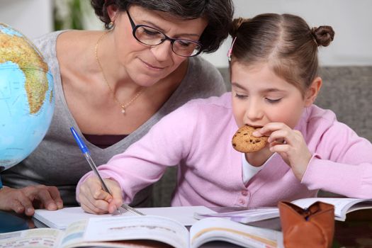 Woman helping her granddaughter with her homework