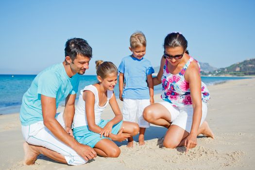 Family of four having fun on tropical beach