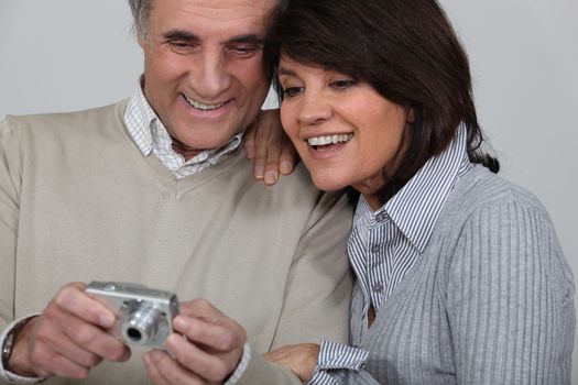 Married couple looking at photographs taken on digital camera