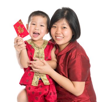 Asian Chinese child receiving monetary gift or red paper packet from parent on Chinese New Year festival, with traditional Cheongsam isolated on white background.
