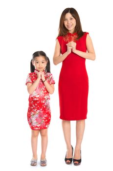 Happy Chinese New Year! Full body Chinese parent and child in traditional Chinese cheongsam greeting to each other, isolated on white background