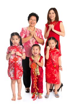 Group of multi generations Asian Chinese family wishing you a happy Chinese New Year, with traditional Cheongsam standing isolated on white background.