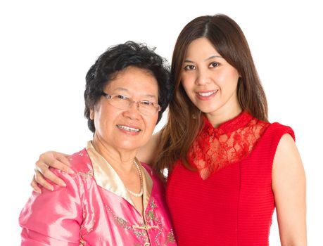 Chinese New Year festival. Happy Asian Chinese senior mother and adult daughter standing isolated on white background
