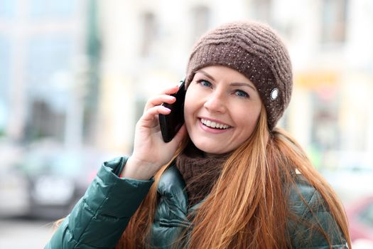 Happy young woman calling by phone